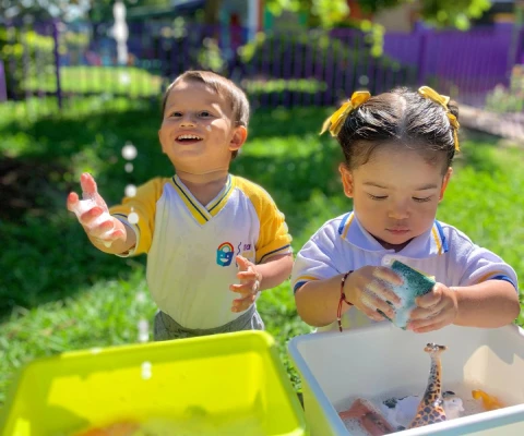niños lavando sus juguetes en el jardín infantil materno