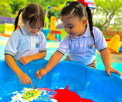 niñas pintando en el jardín infantil materno